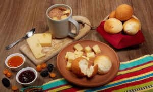 Colombian chocolate with cheese served with buñuelos, almojábanas, pan de yuca, and jams